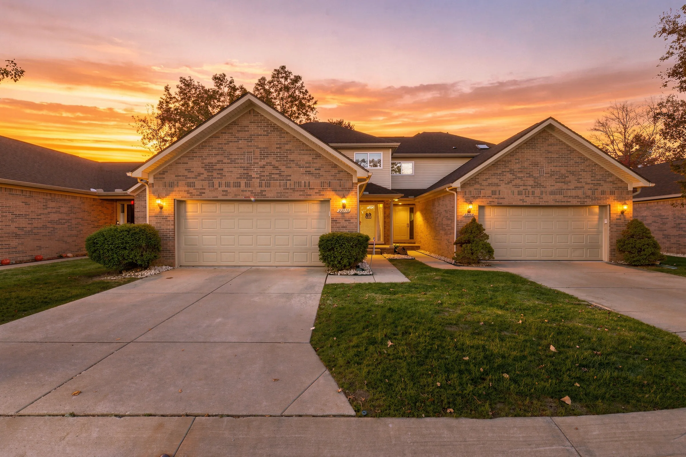 Front of 22176 Brehmer Court at dusk, a brick two-story condo with an attached garage